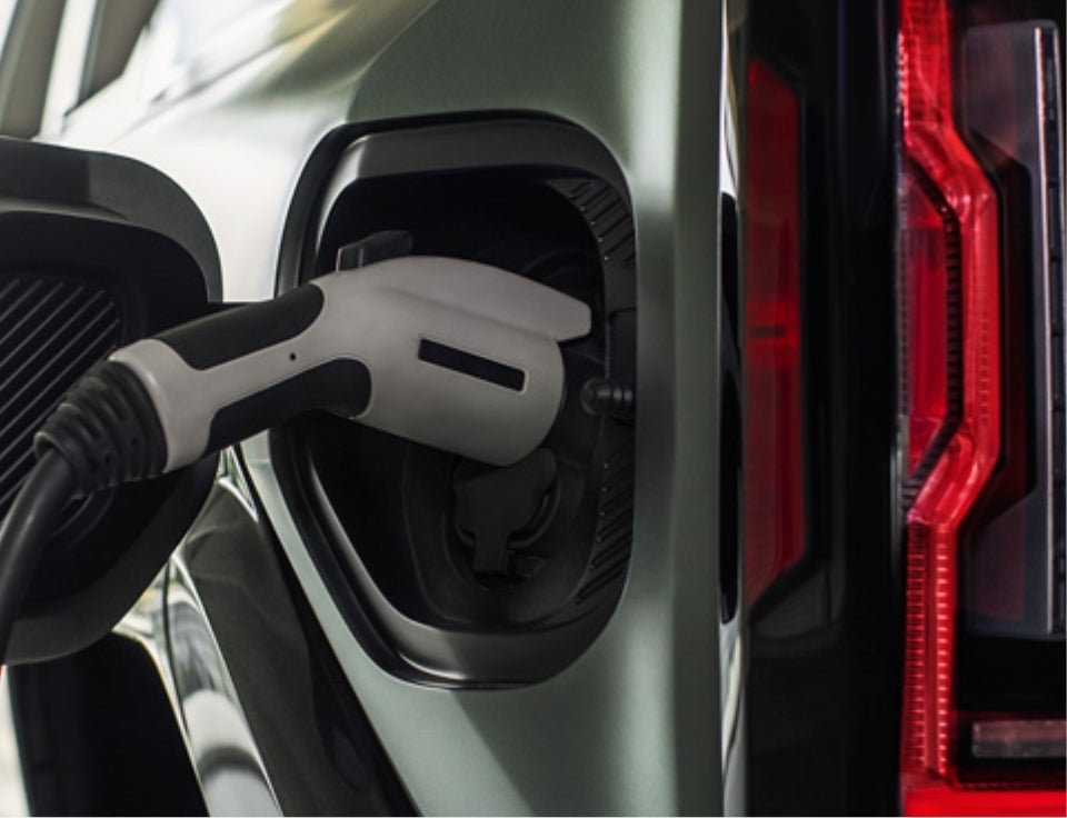 Close up of charging port with charger plugged in on a GMC Hummer EV SUV - Visalia GMC in VISALIA CA